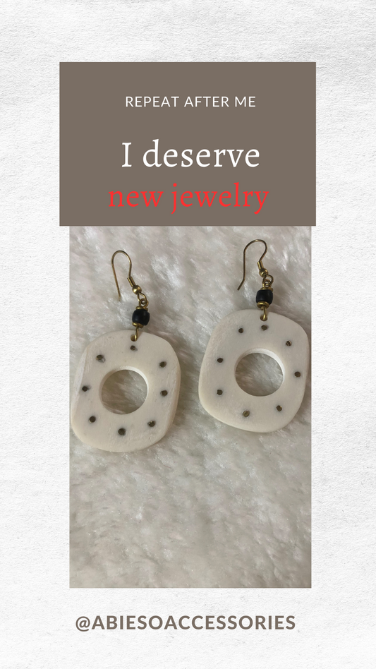 Image of handcrafted earrings made from white bone and brass, featuring dangling bone squares with inlaid brass dots. The earrings are sold as a set and are unique, promoting sustainable fashion and women's empowerment. The earrings measure 1.75 inches in width and 3 inches in height. SKU: KE-JO-0001. Handmade in Kenya.
